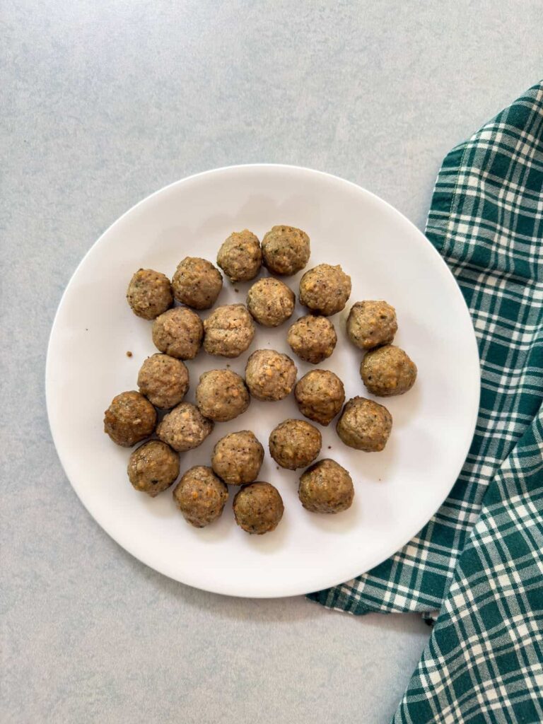 The meatballs on a plate after they've come out of the microwave.