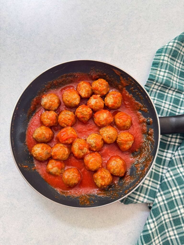 The meatballs and marinara sauce in a medium skillet.