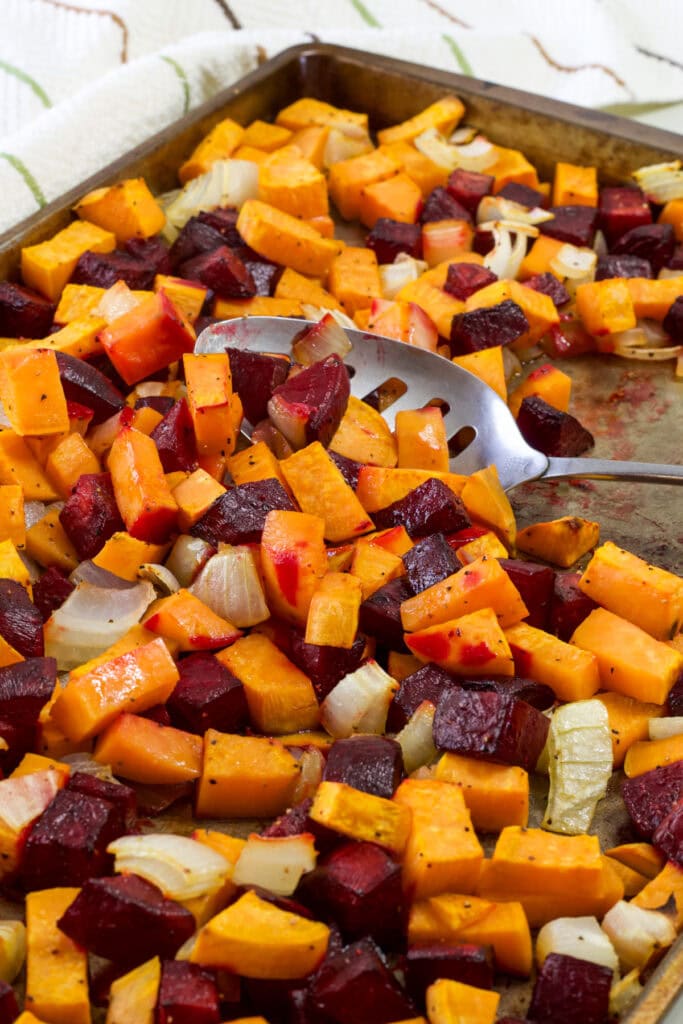 A large rimmed baking sheet with the finished Roasted Beets and Sweet Potatoes.