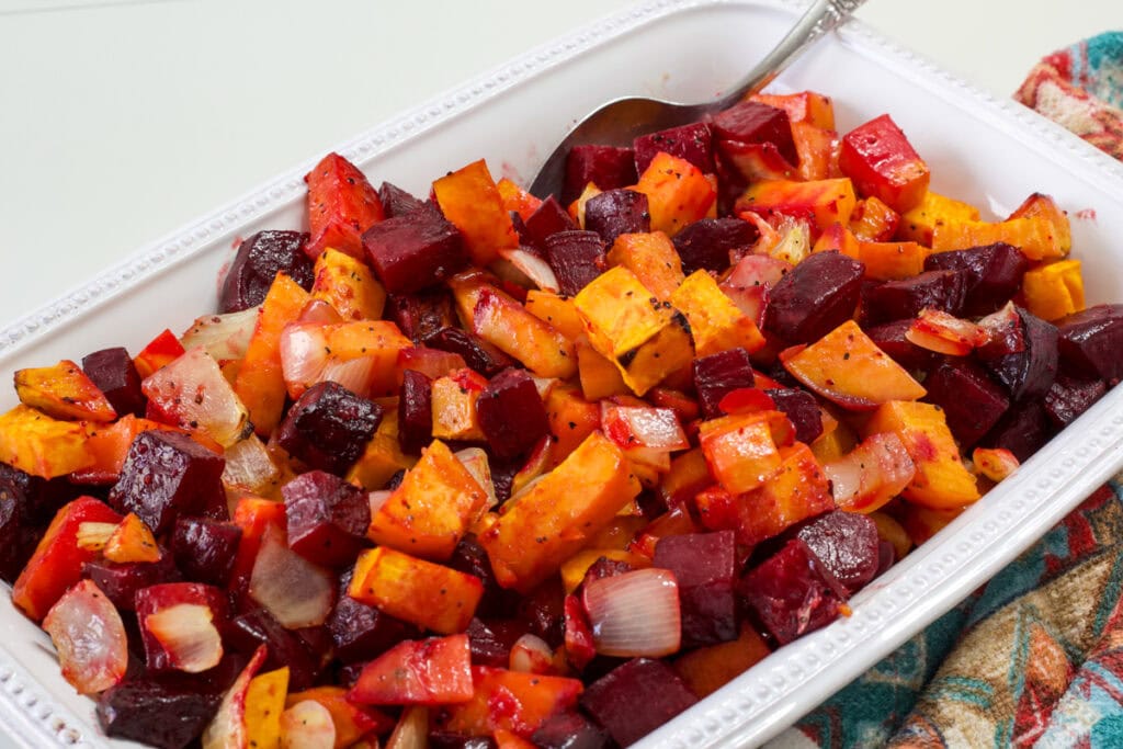A white rectangle serving dish filled with the finished Roasted Beets and Sweet Potatoes.