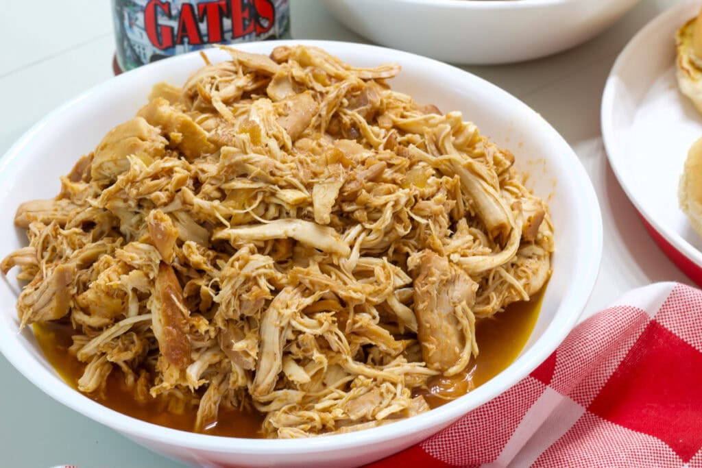 A white serving bowl full of Slow Cooker Barbecue Chicken.