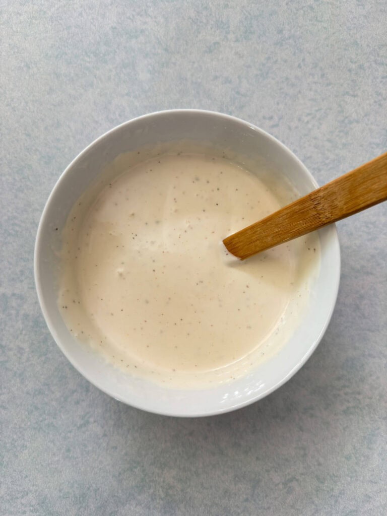 The creamy dressing in a small bowl.