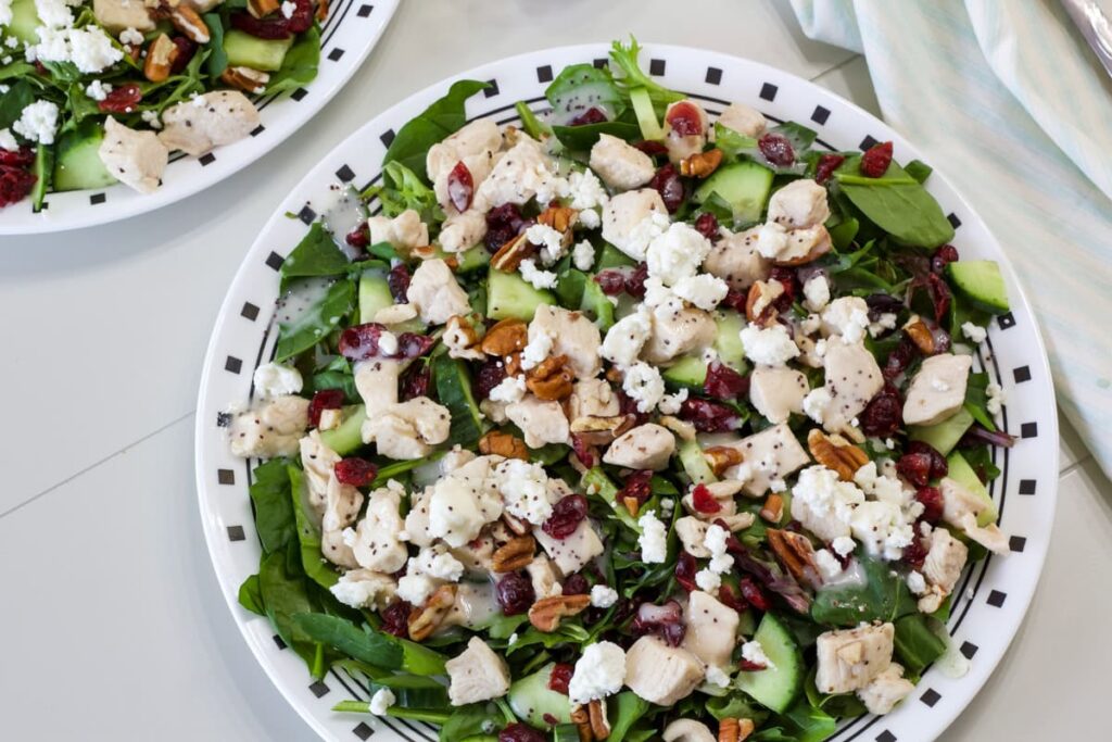 Overhead shot of one Green Salad with Chicken on a plate.