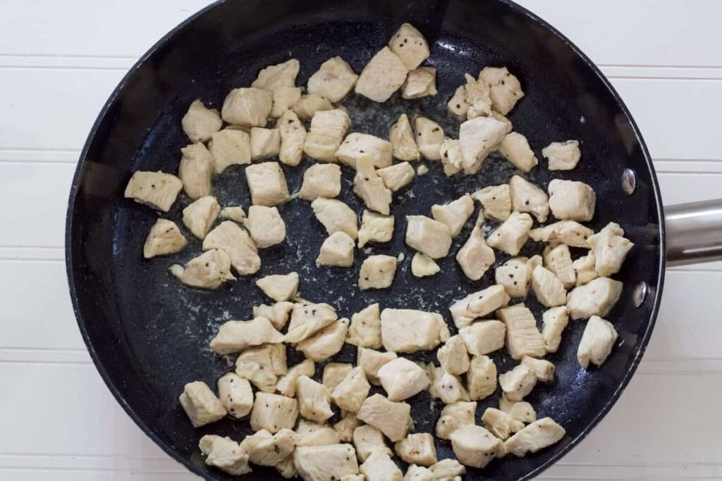 The cut up chicken in a skillet after it's been cooked.
