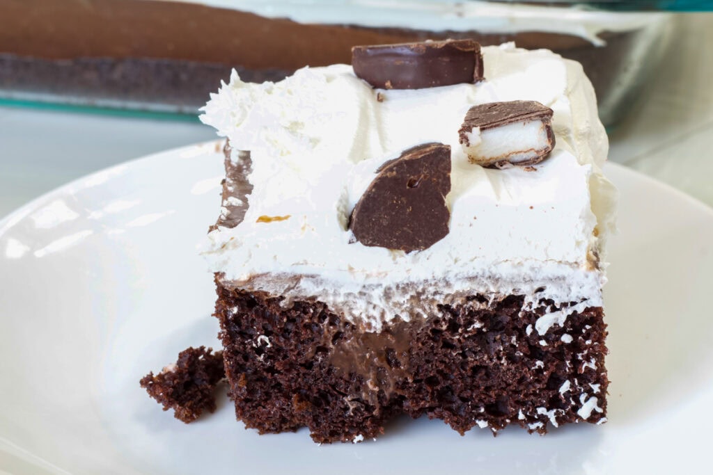 One piece of Peppermint Mocha Poke Cake on a white plate.