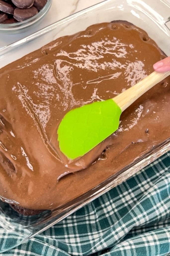 The pudding being spread onto the cake.