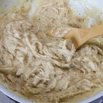 Very close up overhead of the Chicken Gravy in a skillet with a wooden spoon in it.