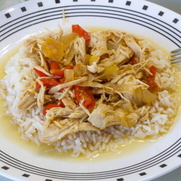 Side close up shot of one serving of crock pot Peach Chicken on a plate with rice.