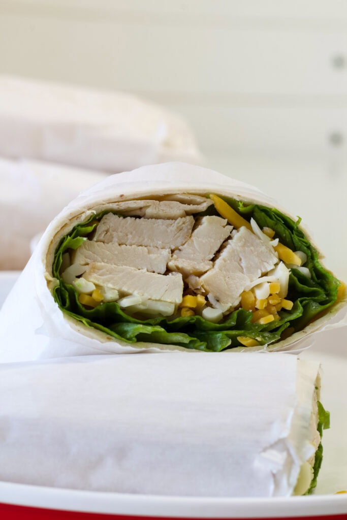 The inside of a Grilled Chicken Cool Wrap (copycat Chick-fil-A) that's wrapped in parchment paper.
