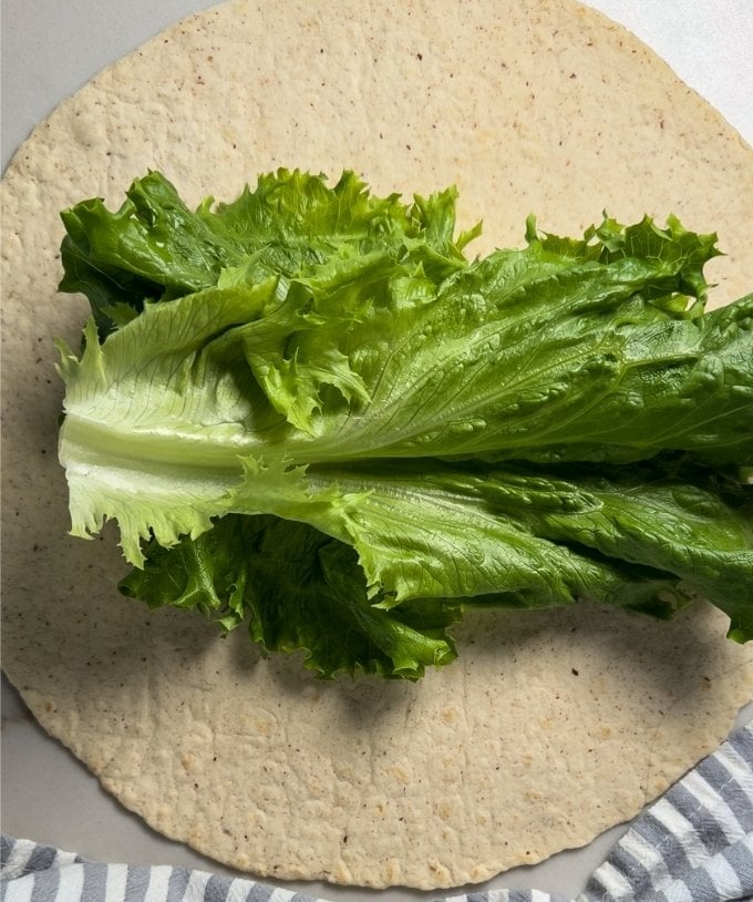 The lettuce leaves on a tortilla.