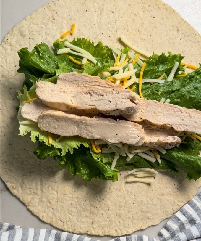 The grilled chicken added on top of the lettuce and cheese.