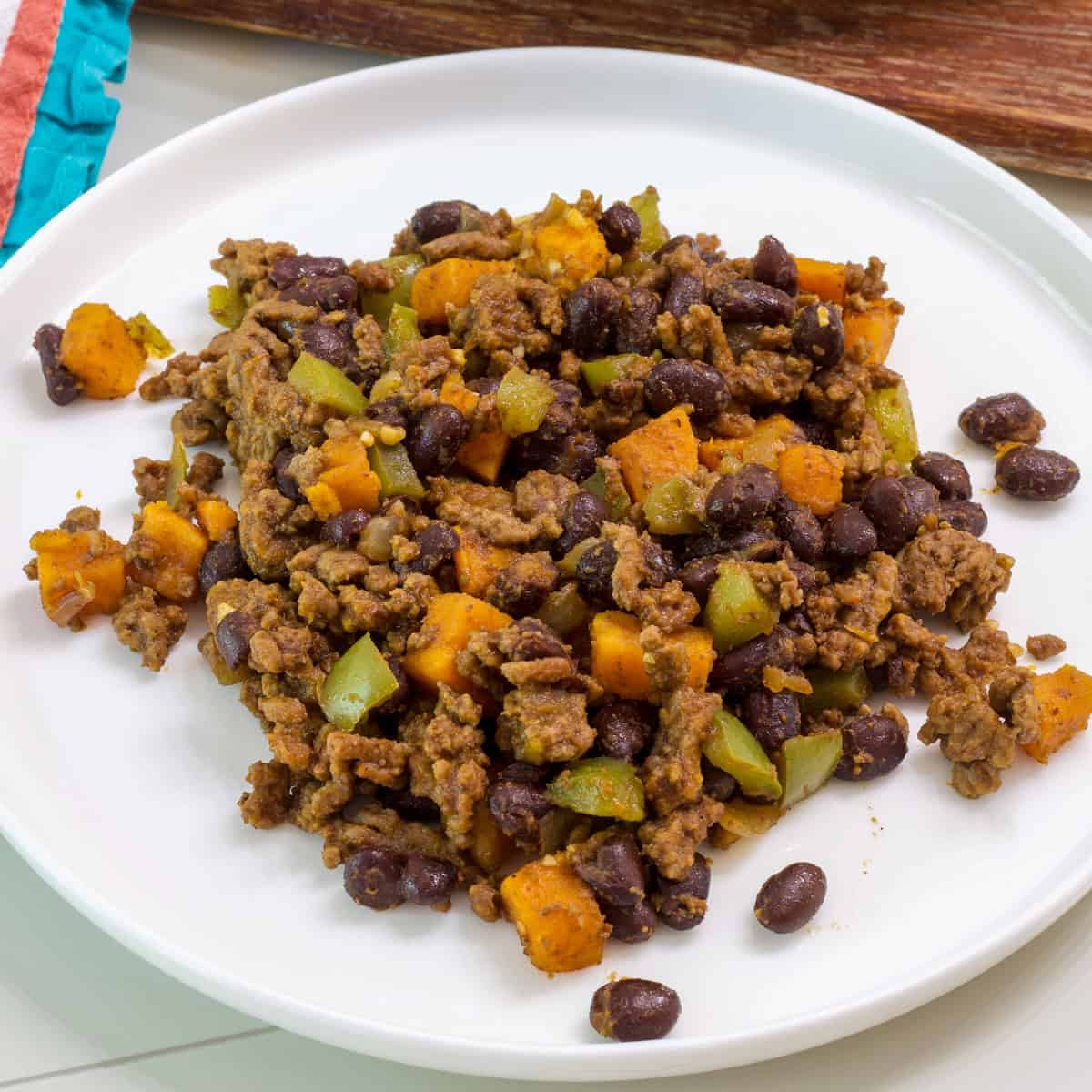 Ground beef and sweet potato hash with black beans in a skillet