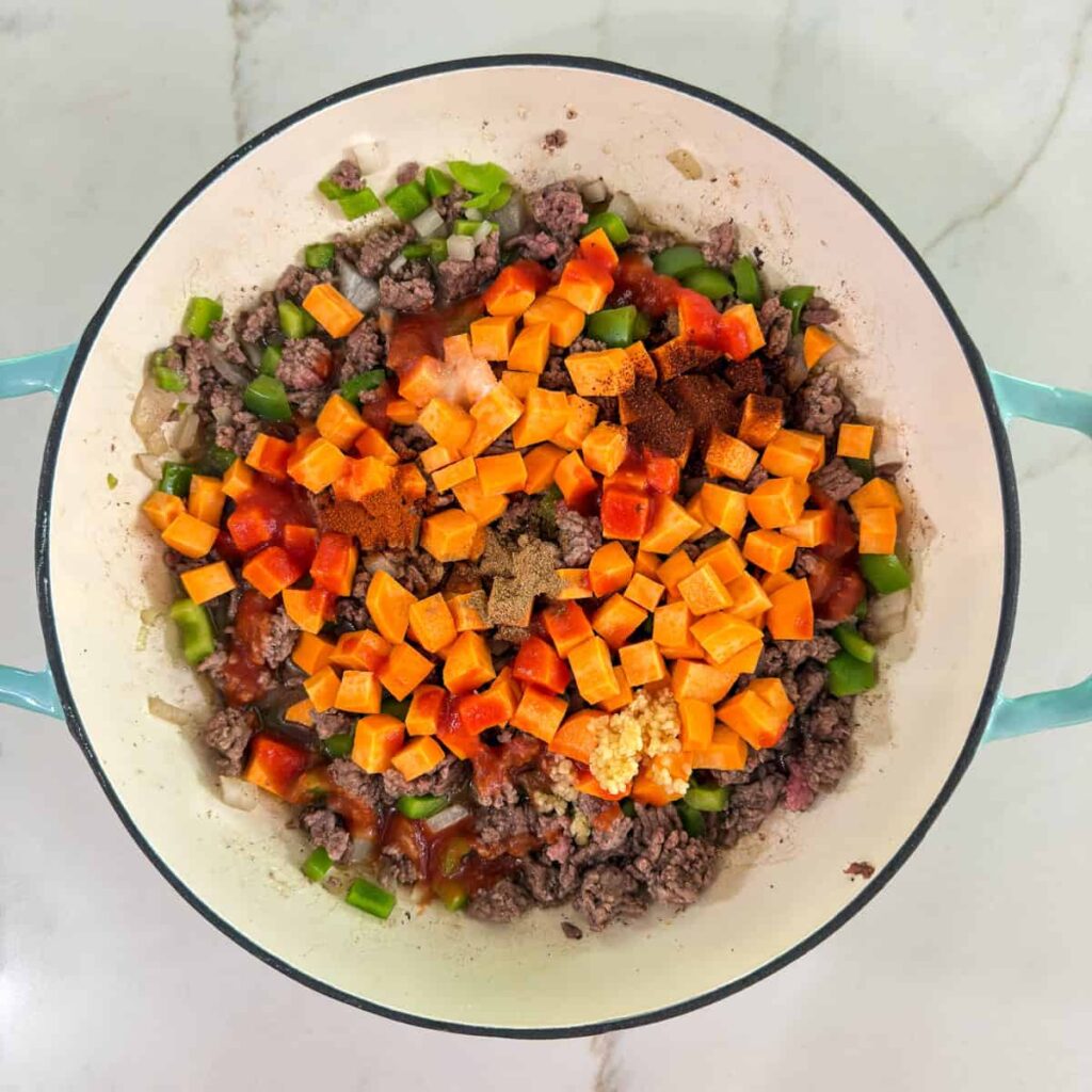 The chopped sweet potato, garlic and spices added to the ground beef mixture.
