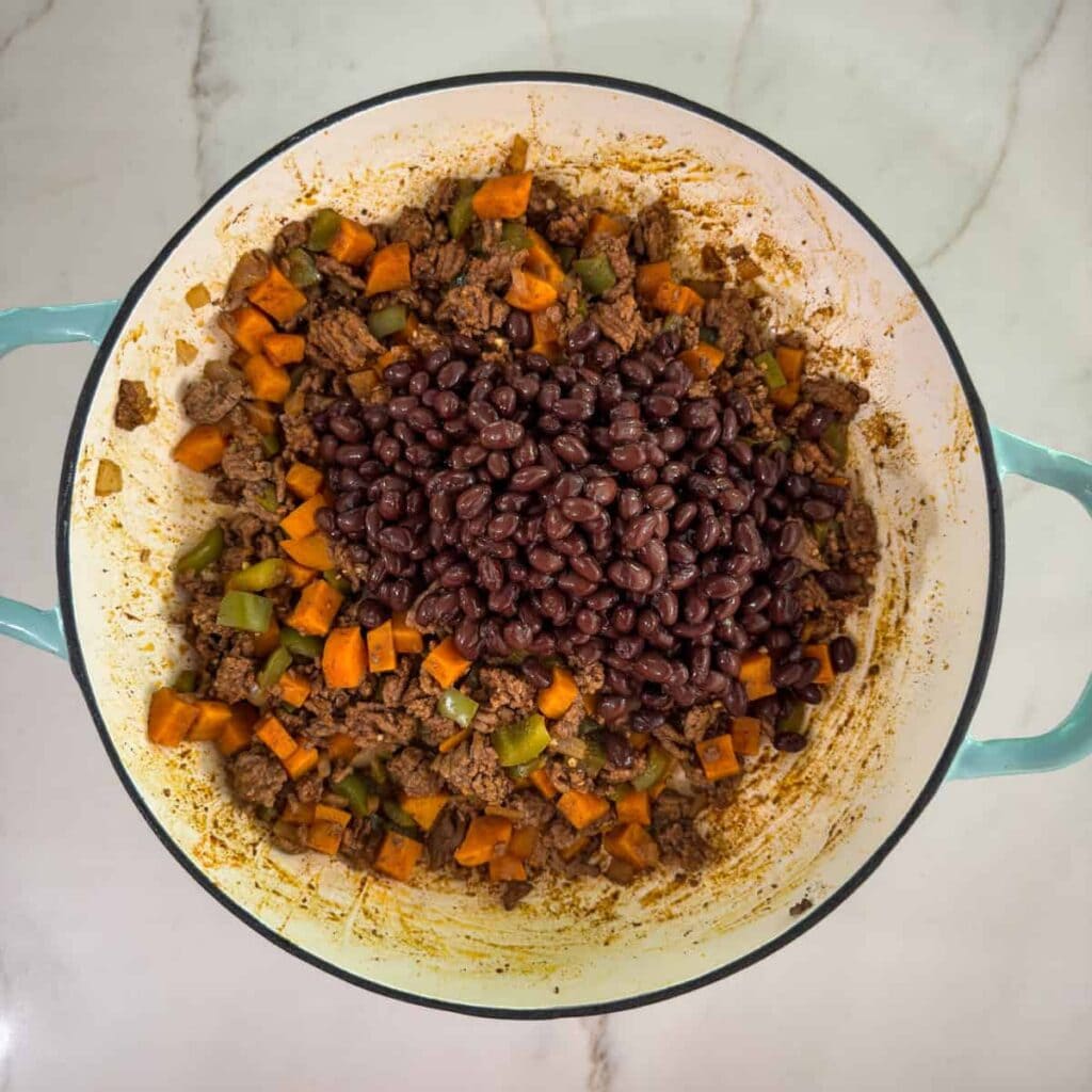 The rinsed and drained black beans added to the ground beef and veggies.