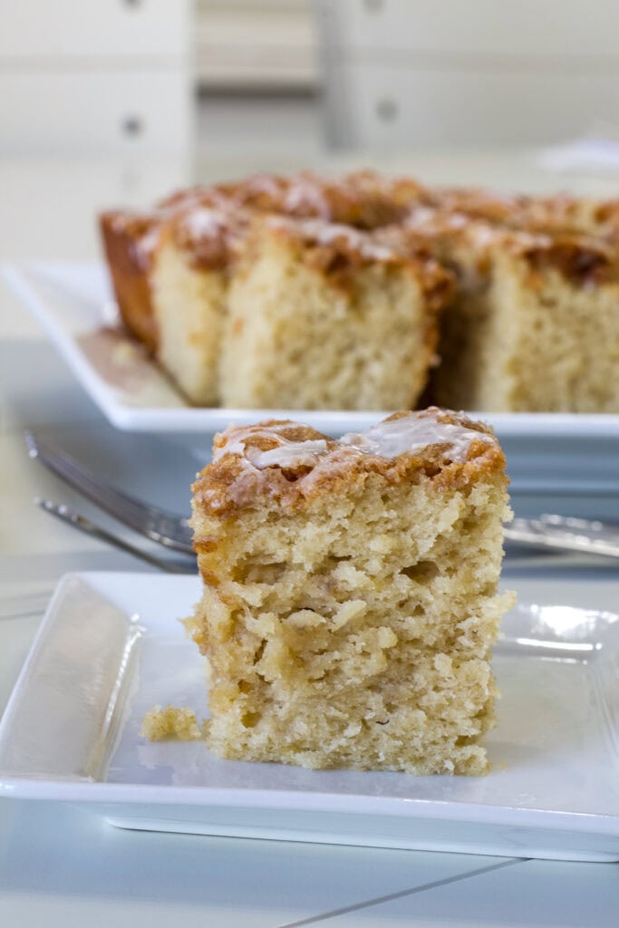 Close-up of one piece of banana sour cream coffee cake on a white plate.