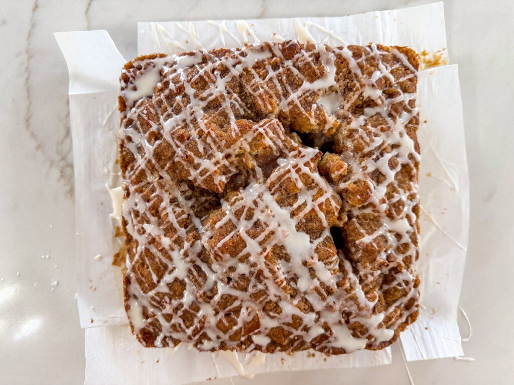 The baked and glazed coffee cake on a piece of parchment paper.
