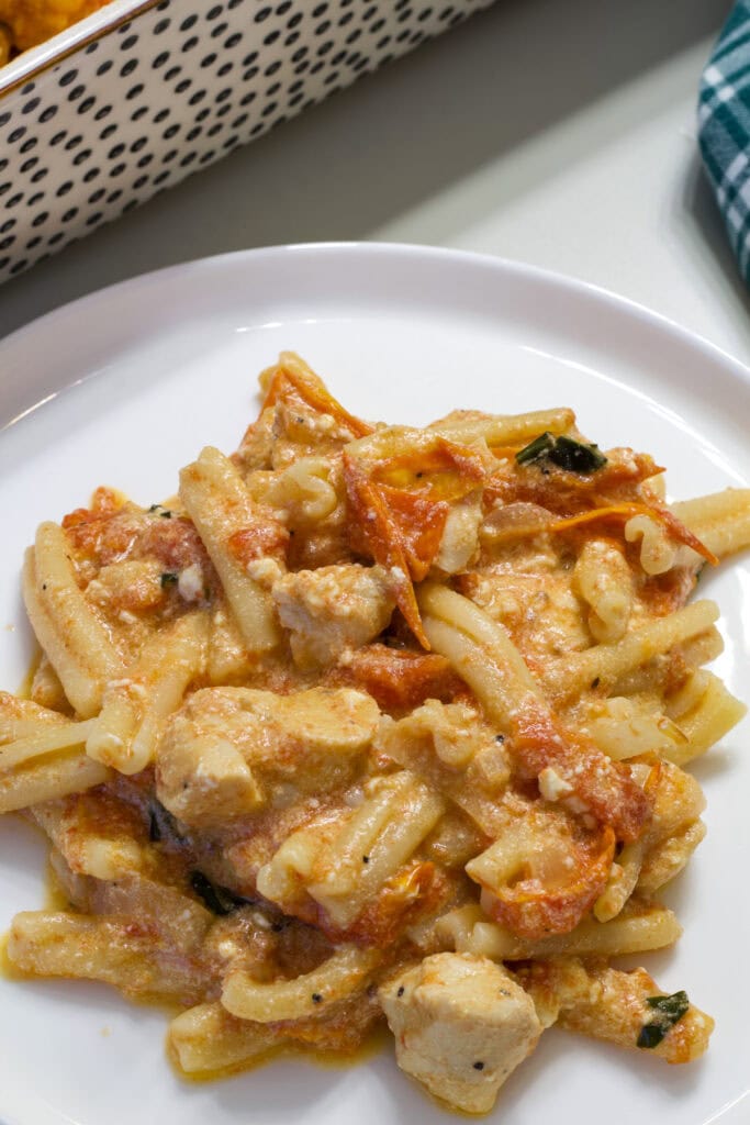 Close up overhead of one serving of Easy Baked Feta Pasta with Chicken on a white plate.