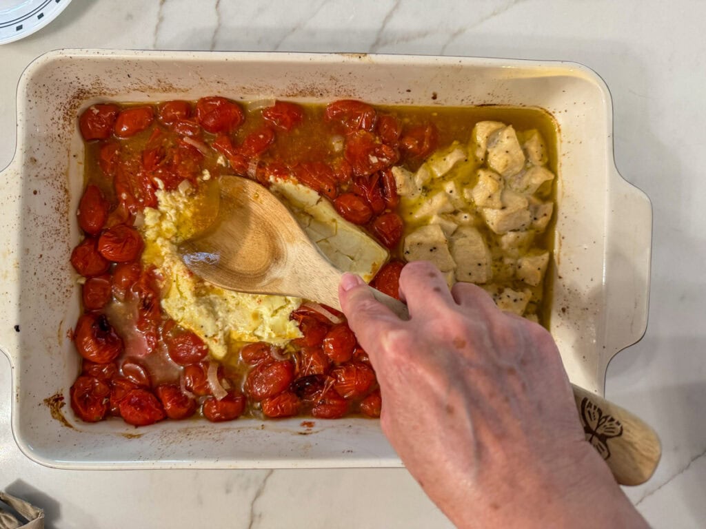 Me smashing the block of feta cheese with a wooden spoon.