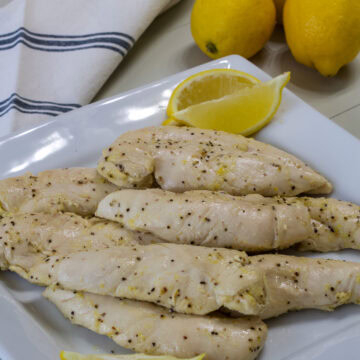 Several Lemon Pepper Chicken Strips on a square white serving platter.