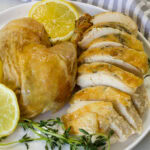Delicious roasted chicken served with fresh lemon slices and herbs, perfect for a flavorful and healthy meal.