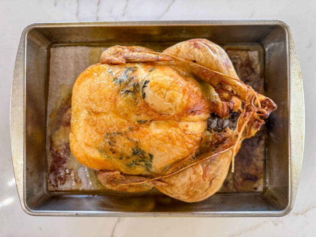 Juicy roasted whole chicken with crispy skin, cooked to perfection and ready to serve. Ideal for family dinners or special occasions, showcasing flavorful, tender poultry.