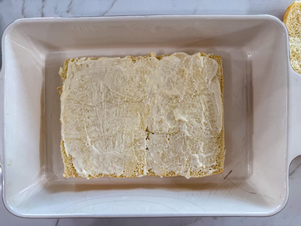 The bottom rolls in the casserole dish with mayo spread on them.