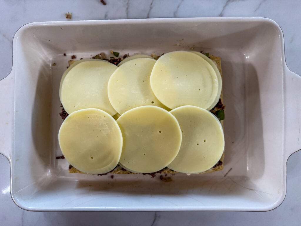 Slices of provolone cheese on top of the meat mixture.
