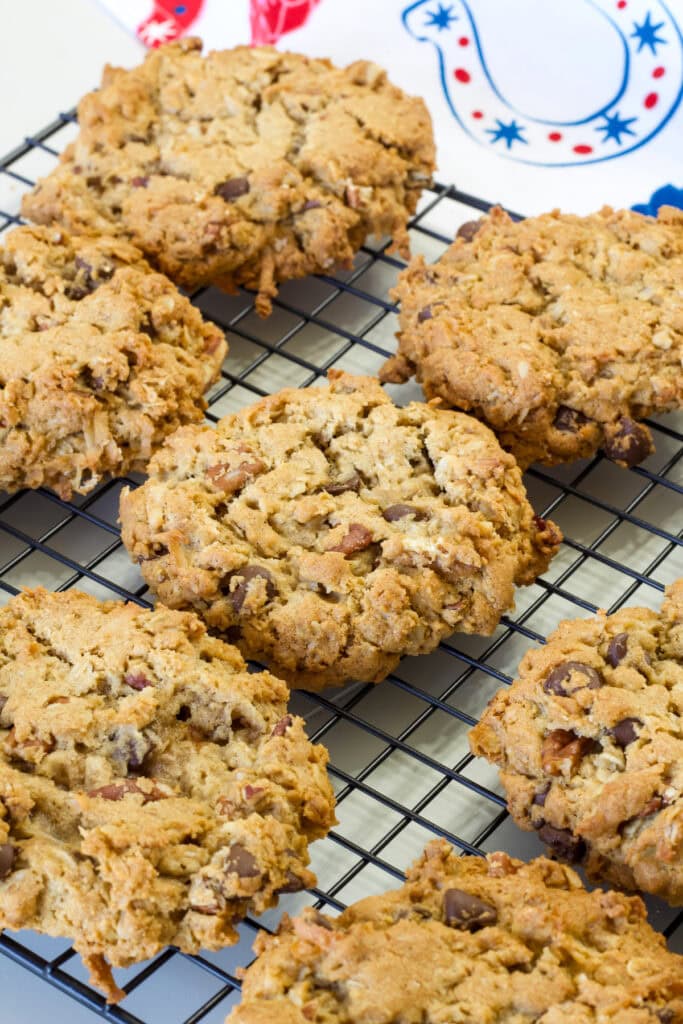 Several Peanut Butter Cowboy Cookies on a black wire cooling rack.