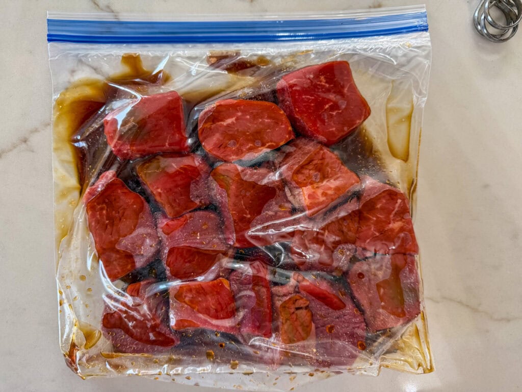 The beef chunks in a zip top bag with the marinade ready to go into the refrigerator.
