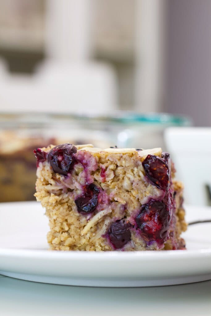 Close-up side view of blueberry baked oatmeal showing the soft oat texture and baked blueberries.