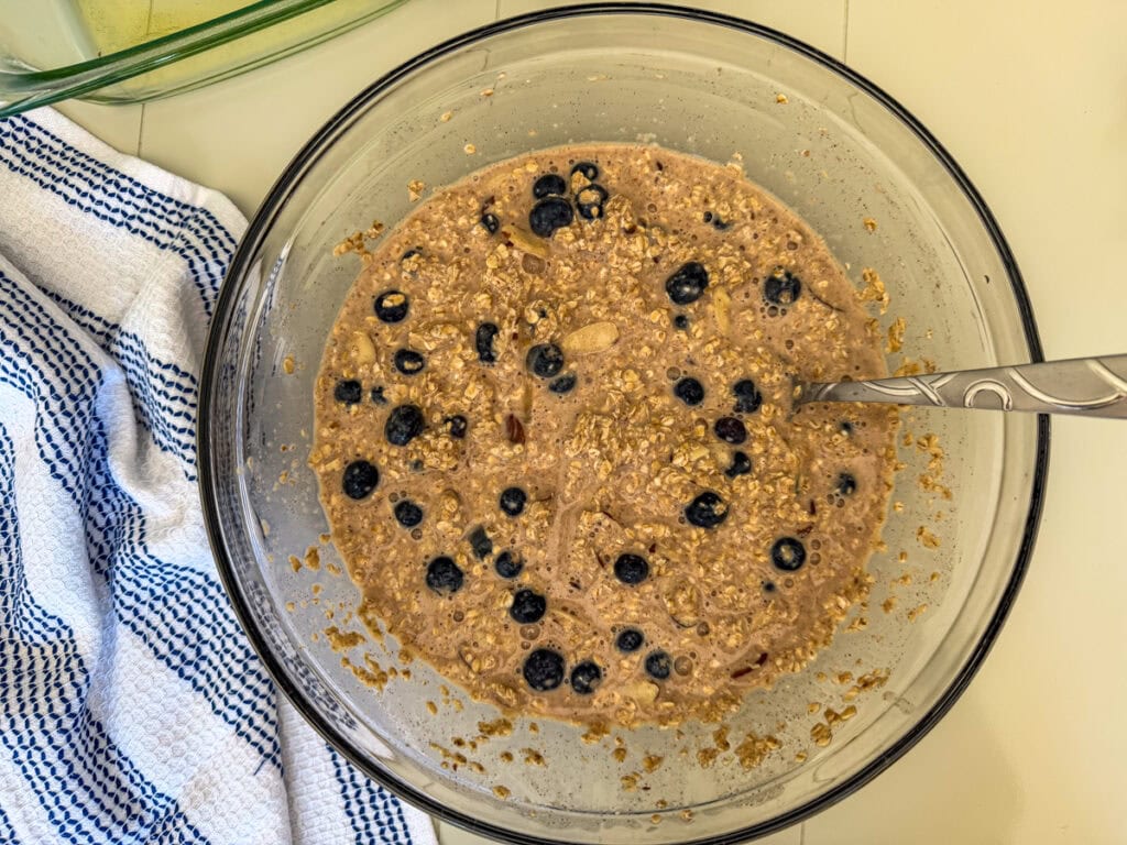 Blueberry baked oatmeal batter mixed in a glass bowl before baking.