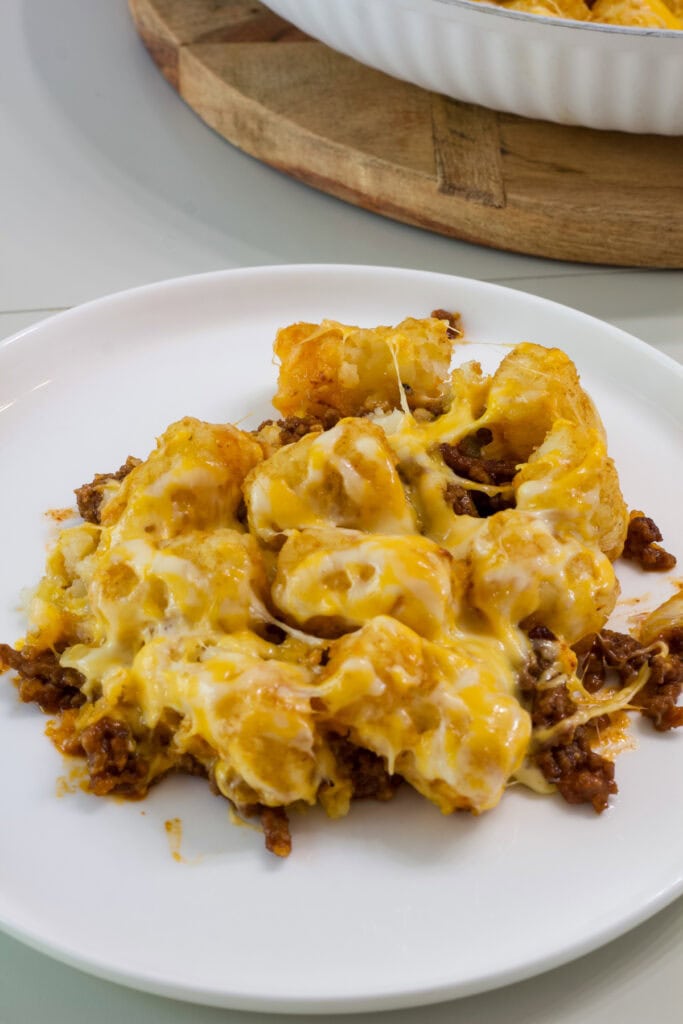 close up of one serving of sloppy joe tater tot casserole on a white plate