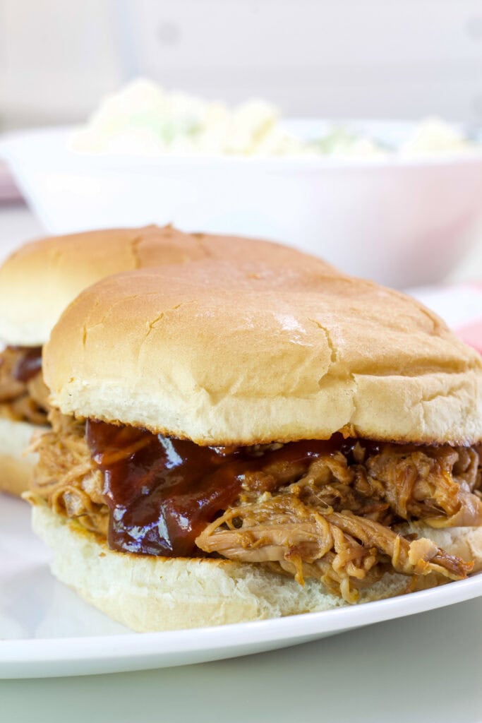 A pulled pork tenderloin sandwich with barbecue sauce on it.