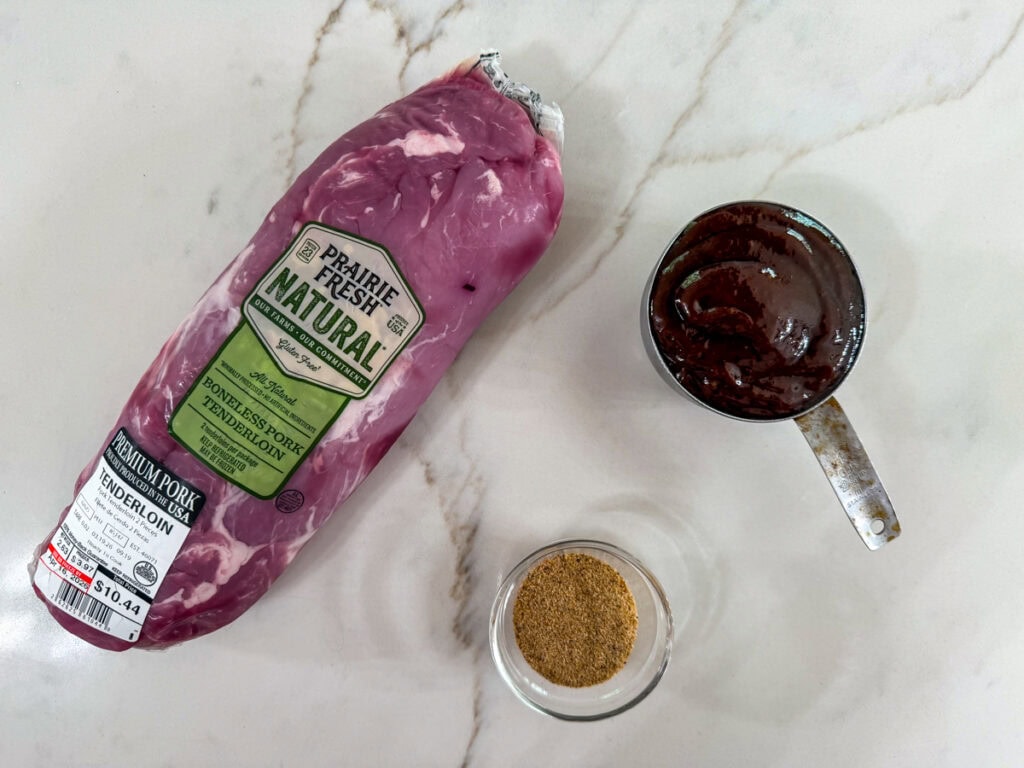 A package of pork tenderloins, measuring cup with barbecue sauce and small bowl with rib rub in it.