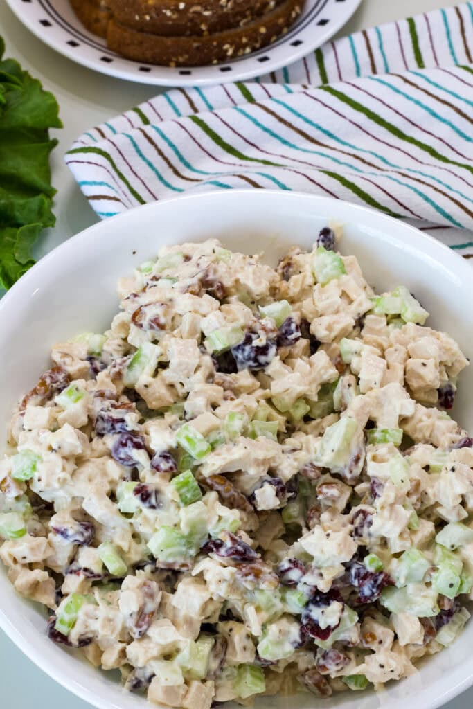 Cranberry and pecan chicken salad made with diced cooked chicken in a white serving bowl.