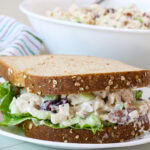 Close up of a cranberry and pecan chicken salad sandwich on wheat bread.