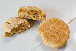 One cookie split in half so the fluffy inside is visible and a cookie upside down so the lightly golden brown bottom is visible.