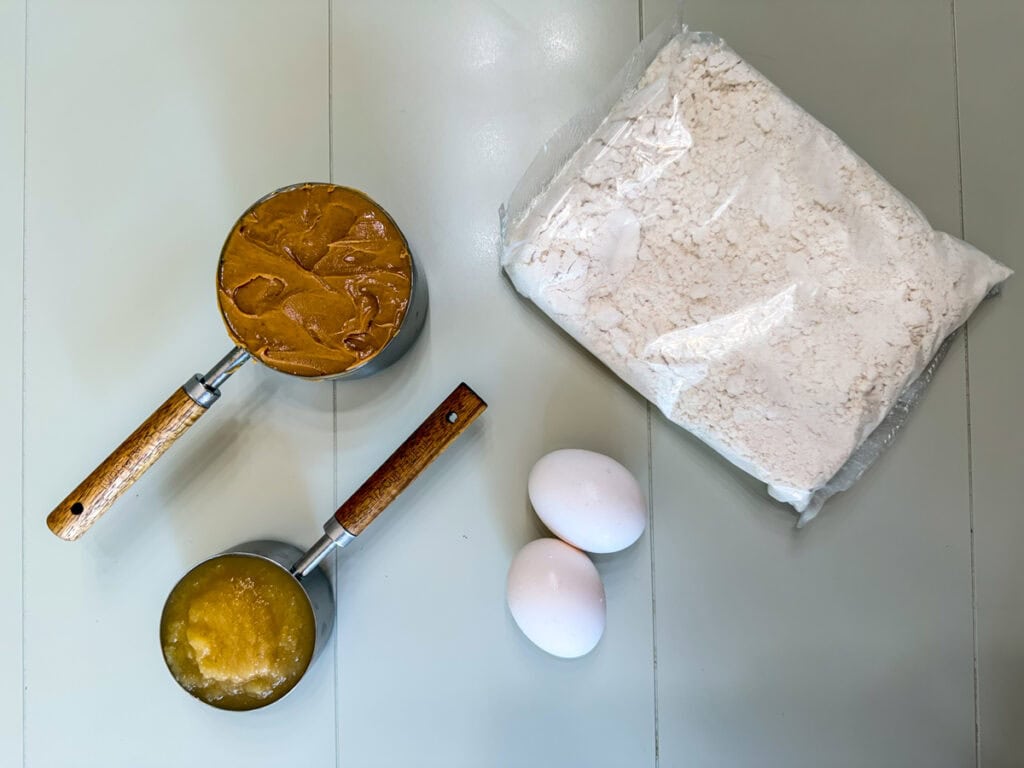 The package of cake mix, cup of peanut butter, half cup of unsweetened applesauce and two eggs needed to make the cookies.