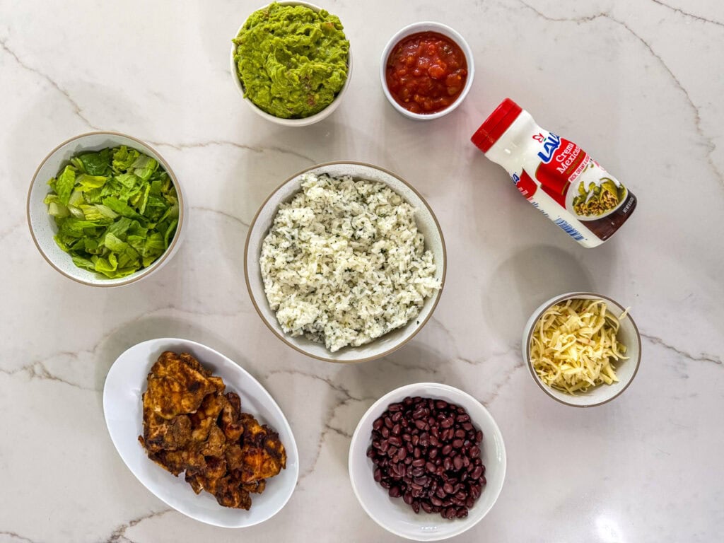 All of the ingredients needed to make four Chipotle Chicken Burrito Bowls.