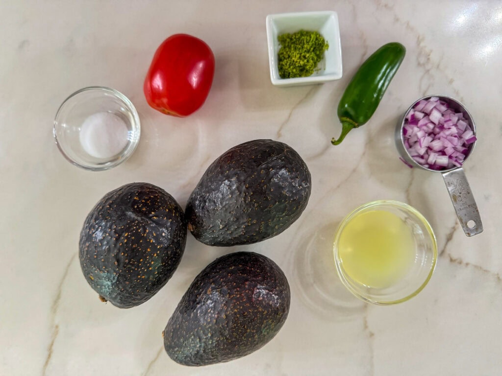 Three avocados, lime juice and zest, salt, tomato, red onion, and a jalapeno used to make the homemade guacamole.