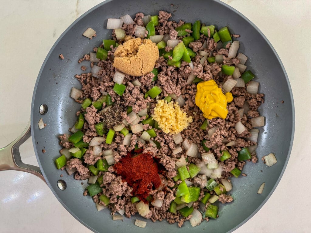 Cooked ground beef, bell pepper, onion and spices in the pan.