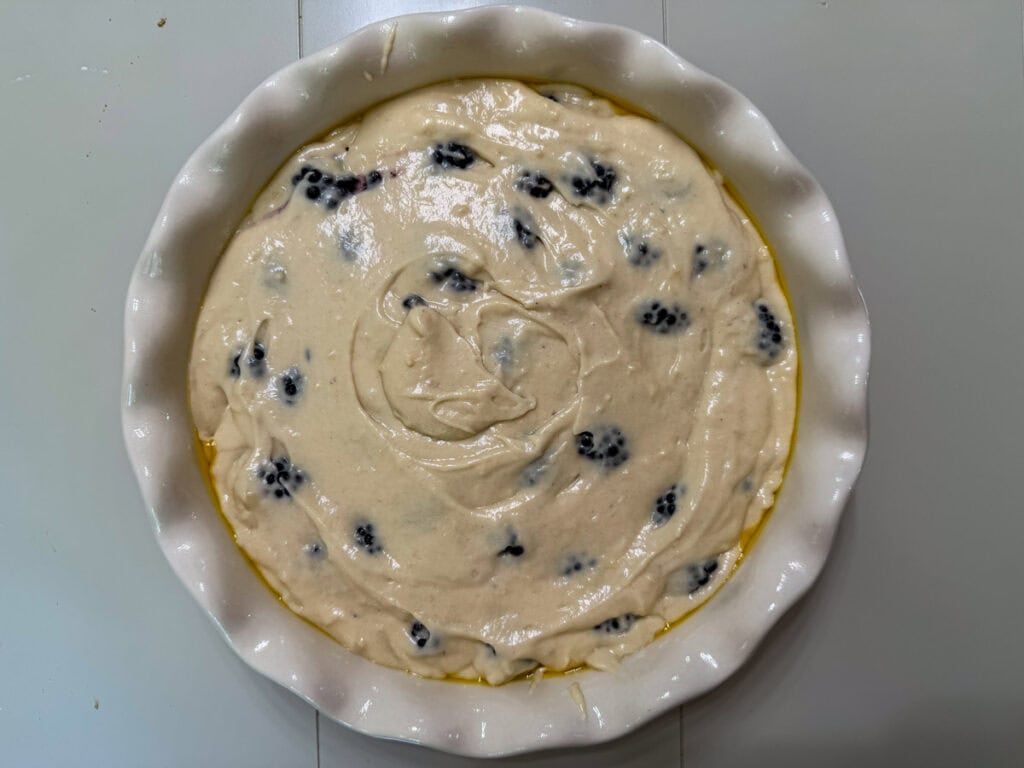 The blackberry cake batter in a 9-inch round baking dish ready for the streusel topping.