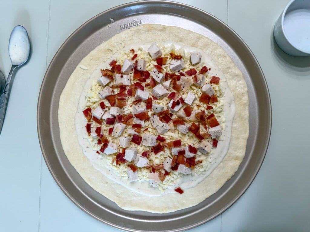 Tender chicken chunks and crispy bacon added on top of the ranch dressing and mozzarella cheese.