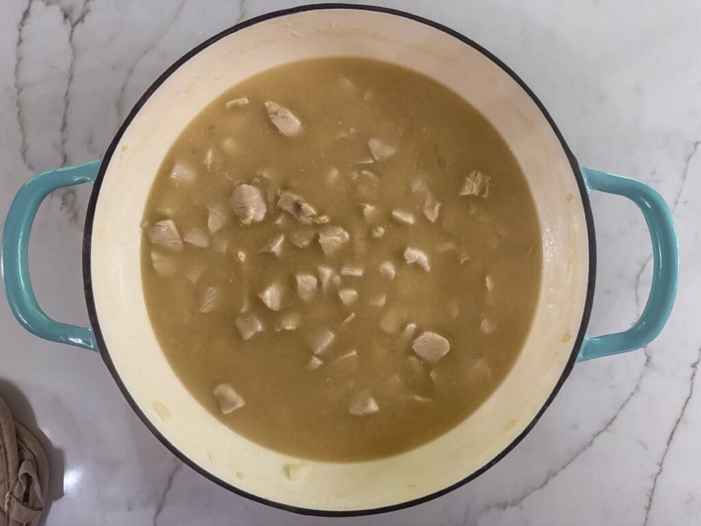 Chicken broth added to the chicken in the pan.