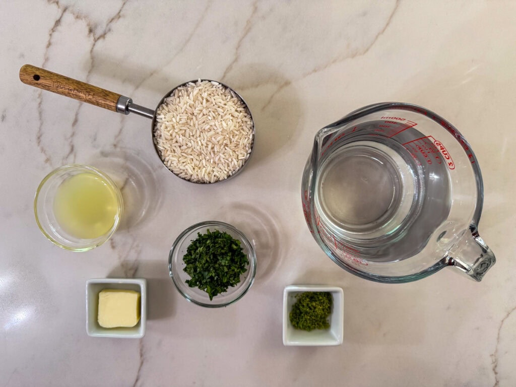 White rice, water, lime juice, butter, cilantro and lime zest measured out and ready to make copycat chipotle cilantro lime rice.
