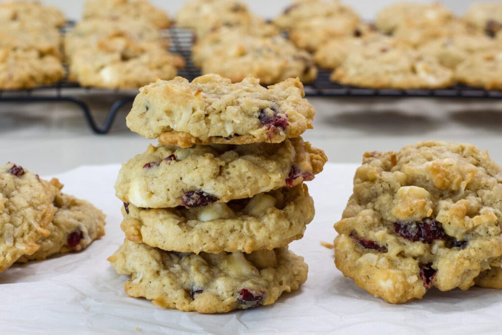 A stack of four cowgirl cookies with several cookies next to it and in the background.