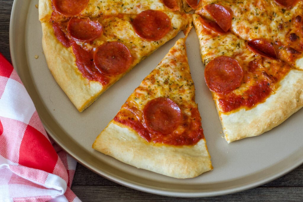 Half a pepperoni pizza with one slice pulled out.