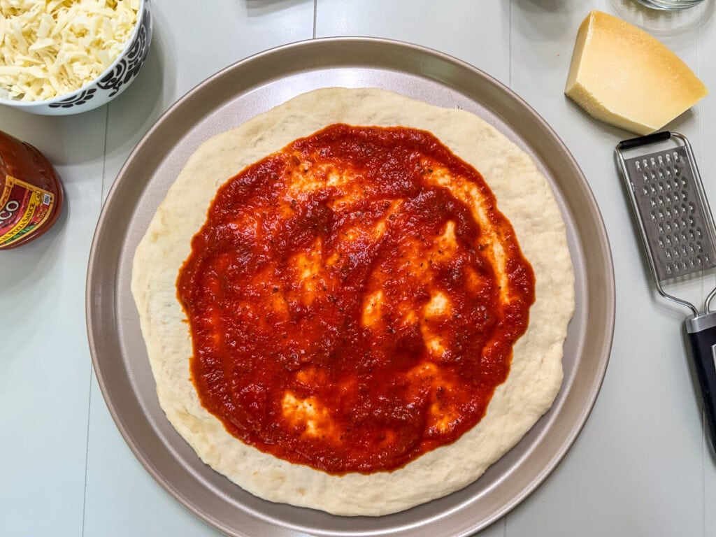 Pizza sauce spread onto the pizza dough.