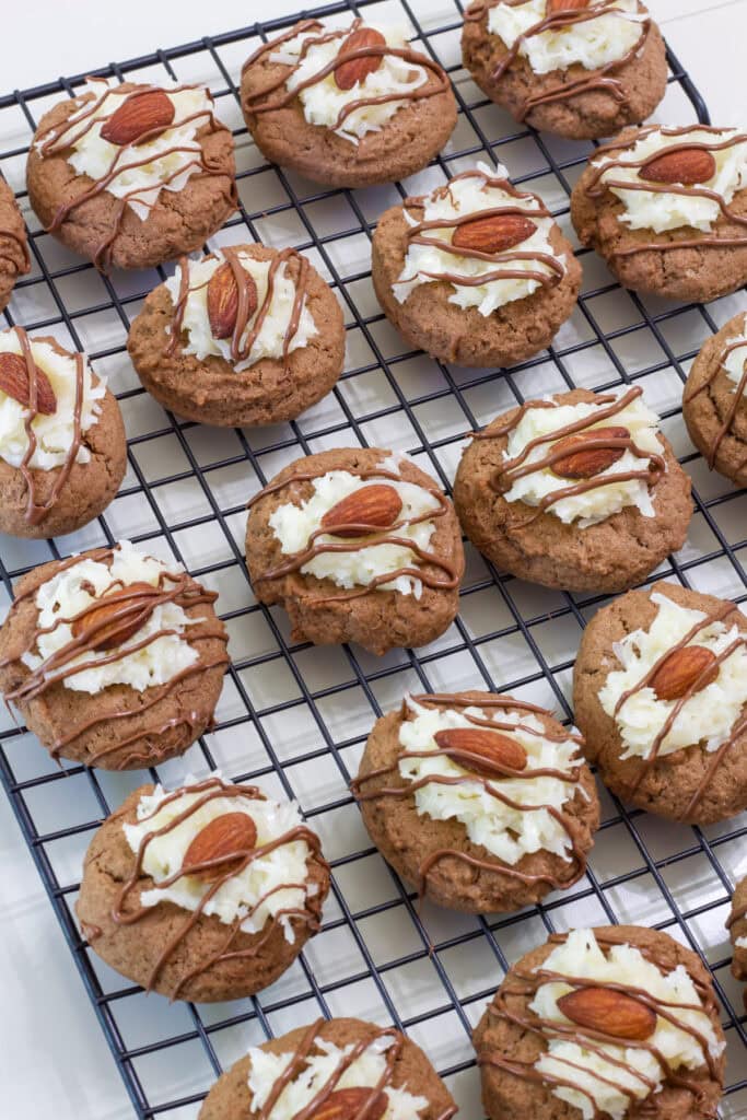 Several Almond Joy Cookies on a black wire cooling rack.