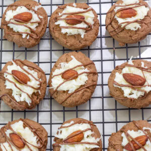 Nine Almond Joy Cookies on a wire cooling rack.